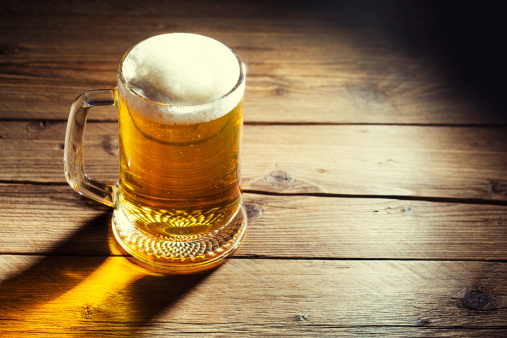 birra, boccale su tavolo di legno rustico, illuminato dal sole