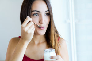 young woman at home eating yogurt