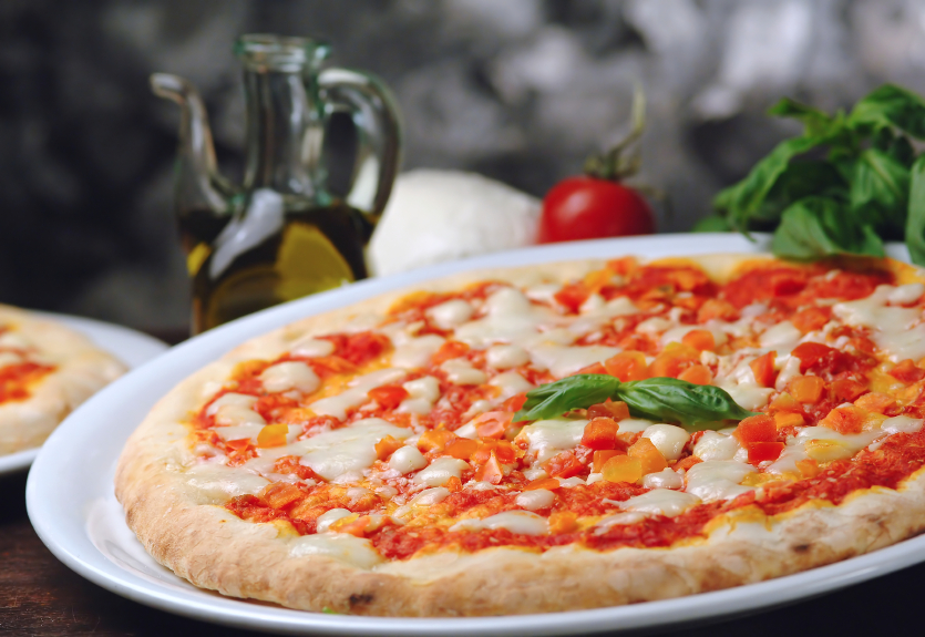 Freshly baked tomato and mozzarella pizza olio extravergine basilico