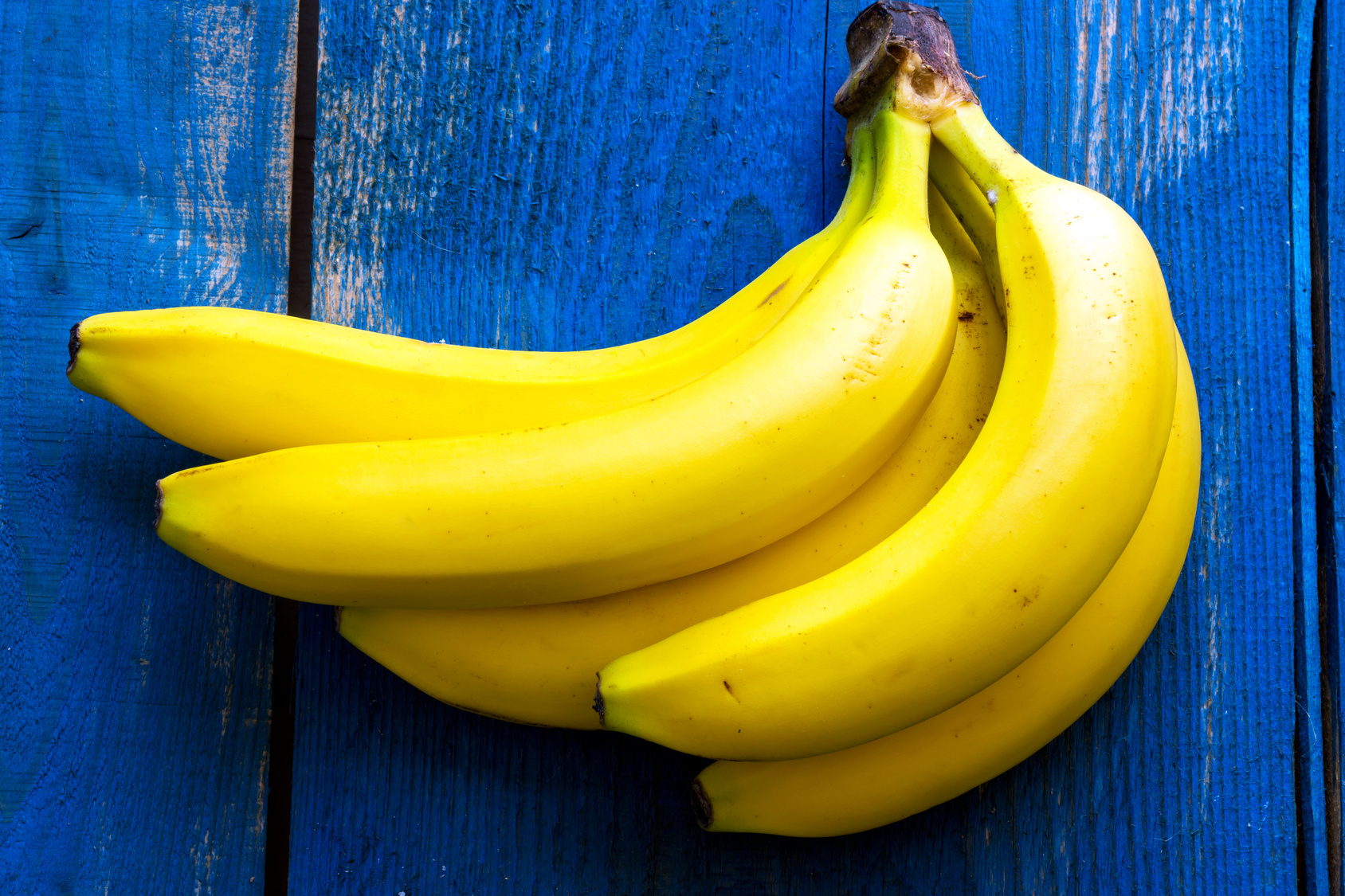 scarti, casco di banane su sfondo di legno blu