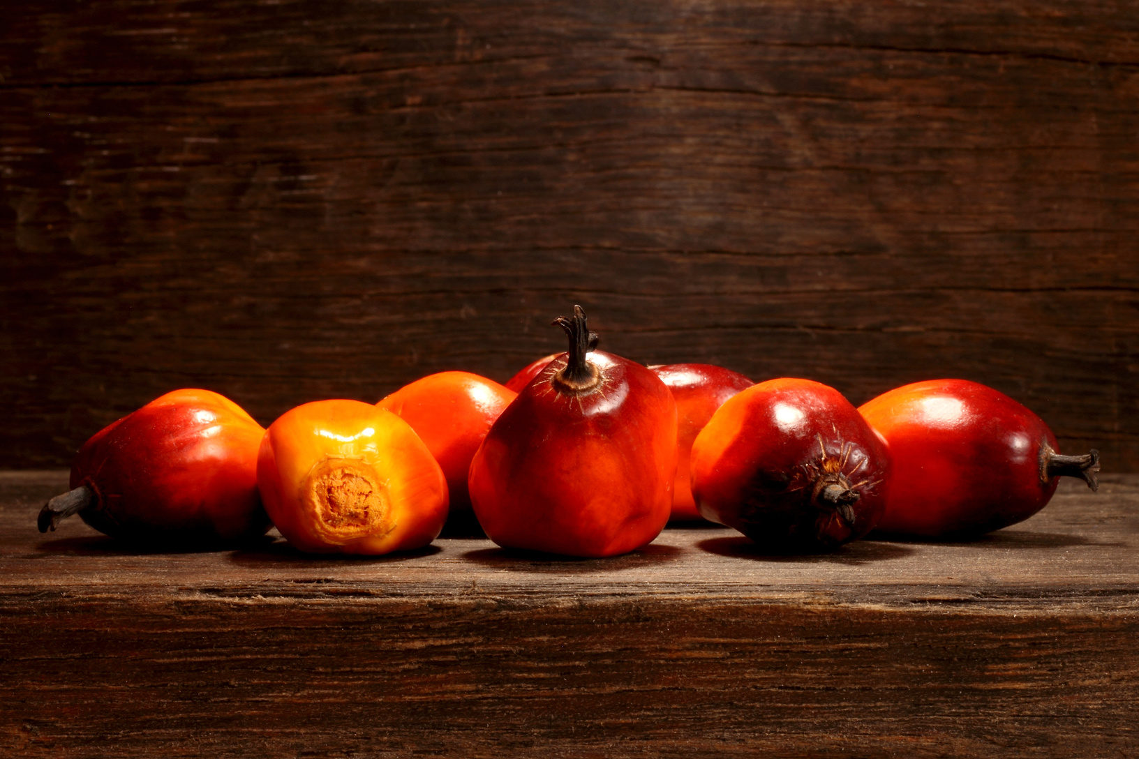 Frutti della palma da olio su una tavola di legno; concept: olio di palma