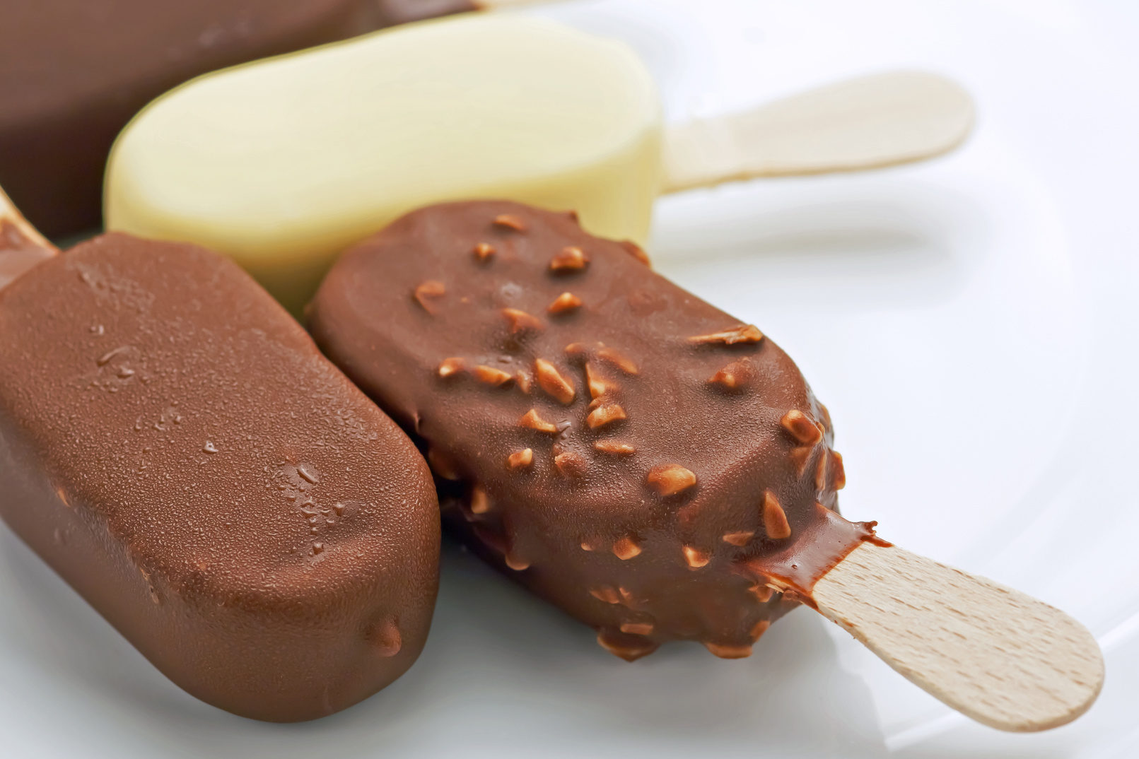 Gelati ricoperti di cioccolato con stecco assortiti; concept: gelati barilla, algida
