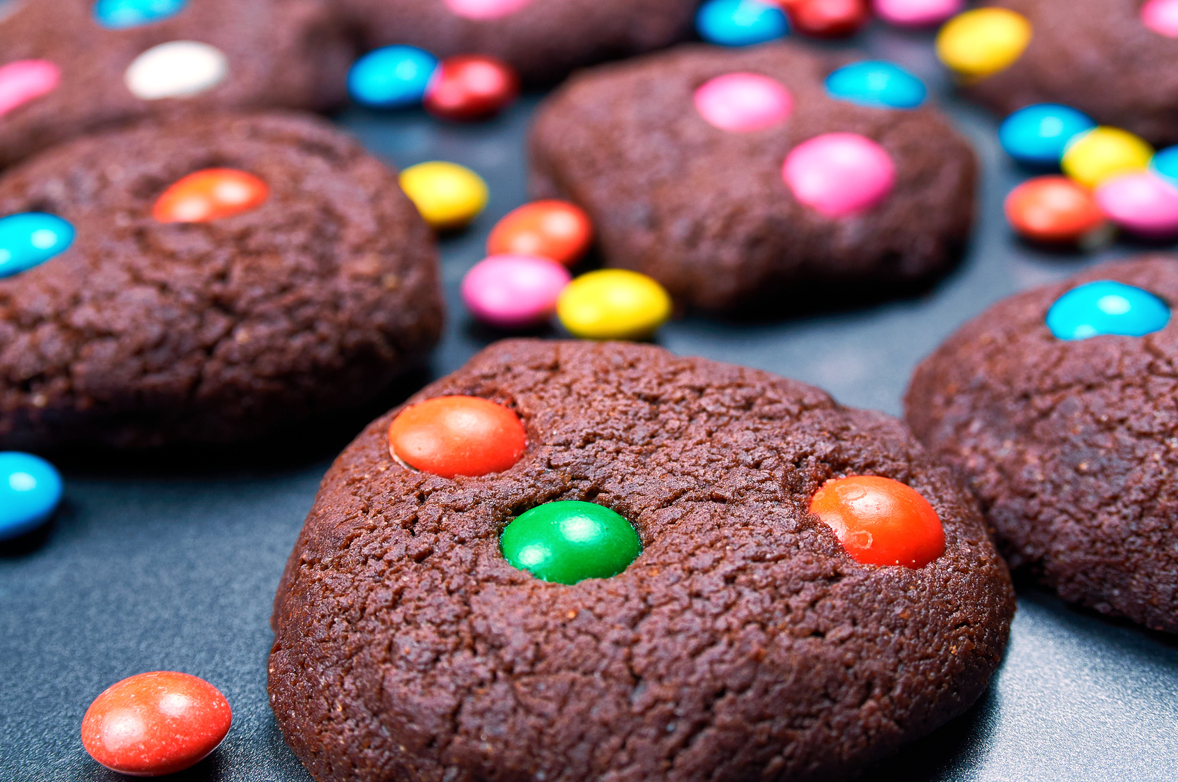 Chocolate cakes made by children. Cookies with colorful candies