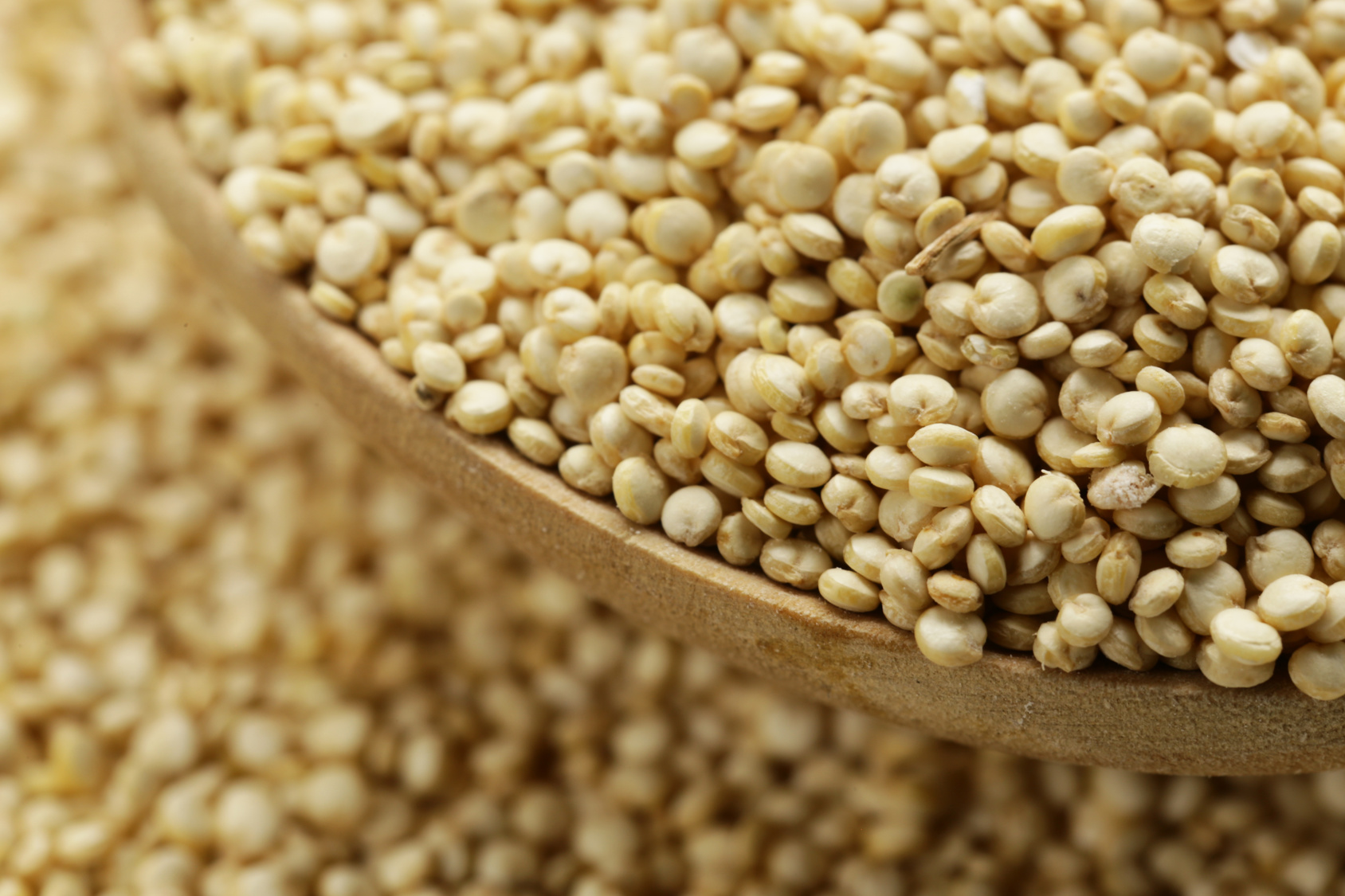 Grani di quinoa in cucchiaio di legno
