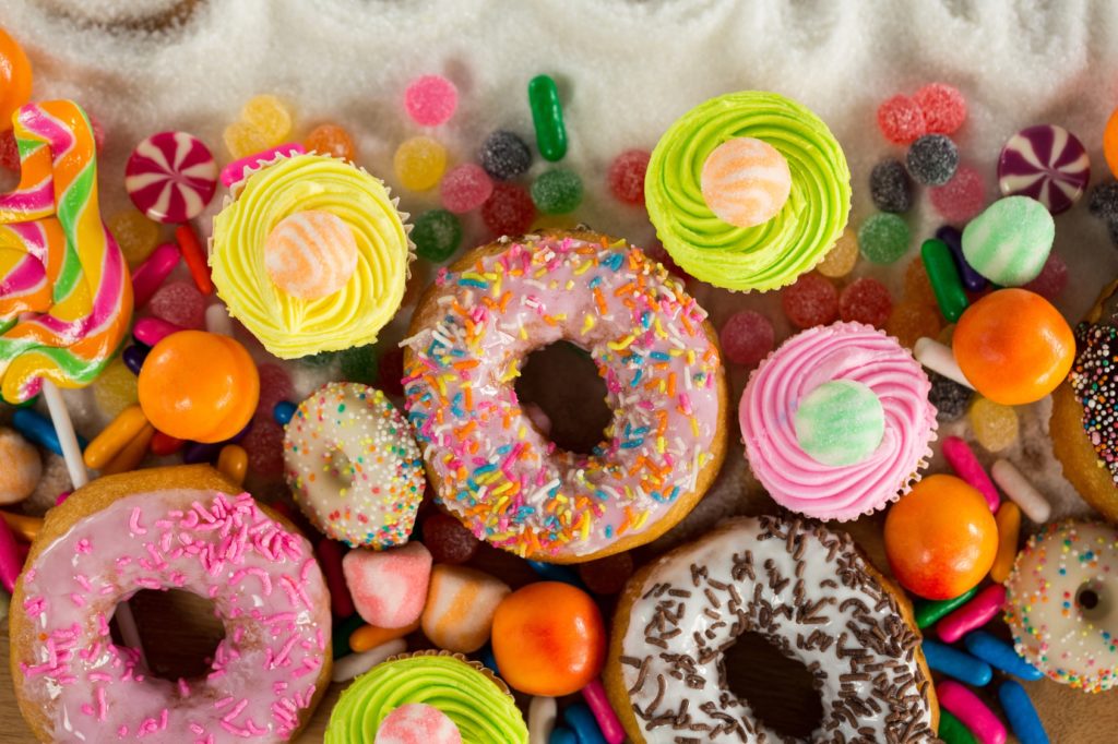 Donuts, cupcake dolci e caramelle multicolore; concept: zucchero