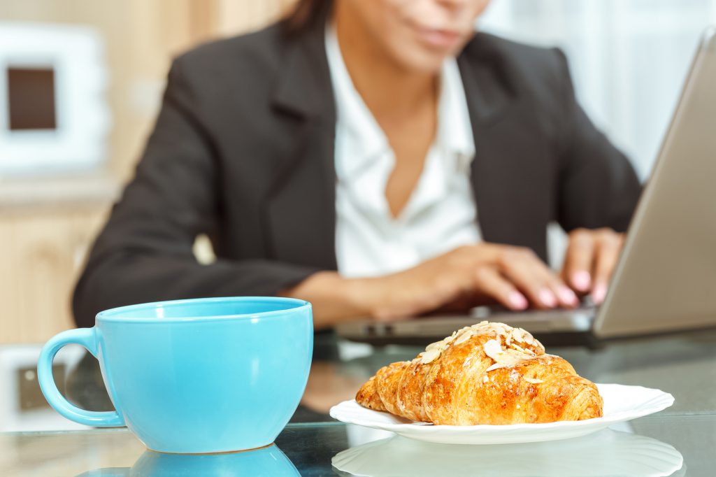 Businesswoman with cup of coffe and croissant