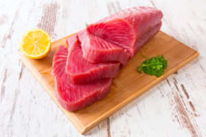 Filetto di tonno crudo su un tagliere con alcune fette tagliate