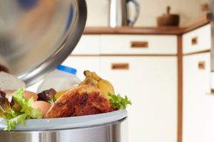 Pattumiera aperta in una cucina piena di cibo; concept: spreco alimentare