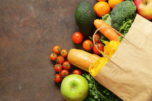 Frutta e verdura spuntano da un sacchetto di carta