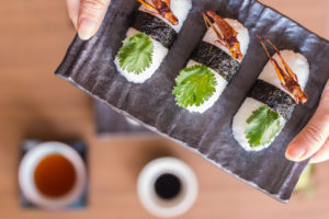 Cavallette fritte servite su polpette di riso con alga; concept: insetti, sushi, novel food