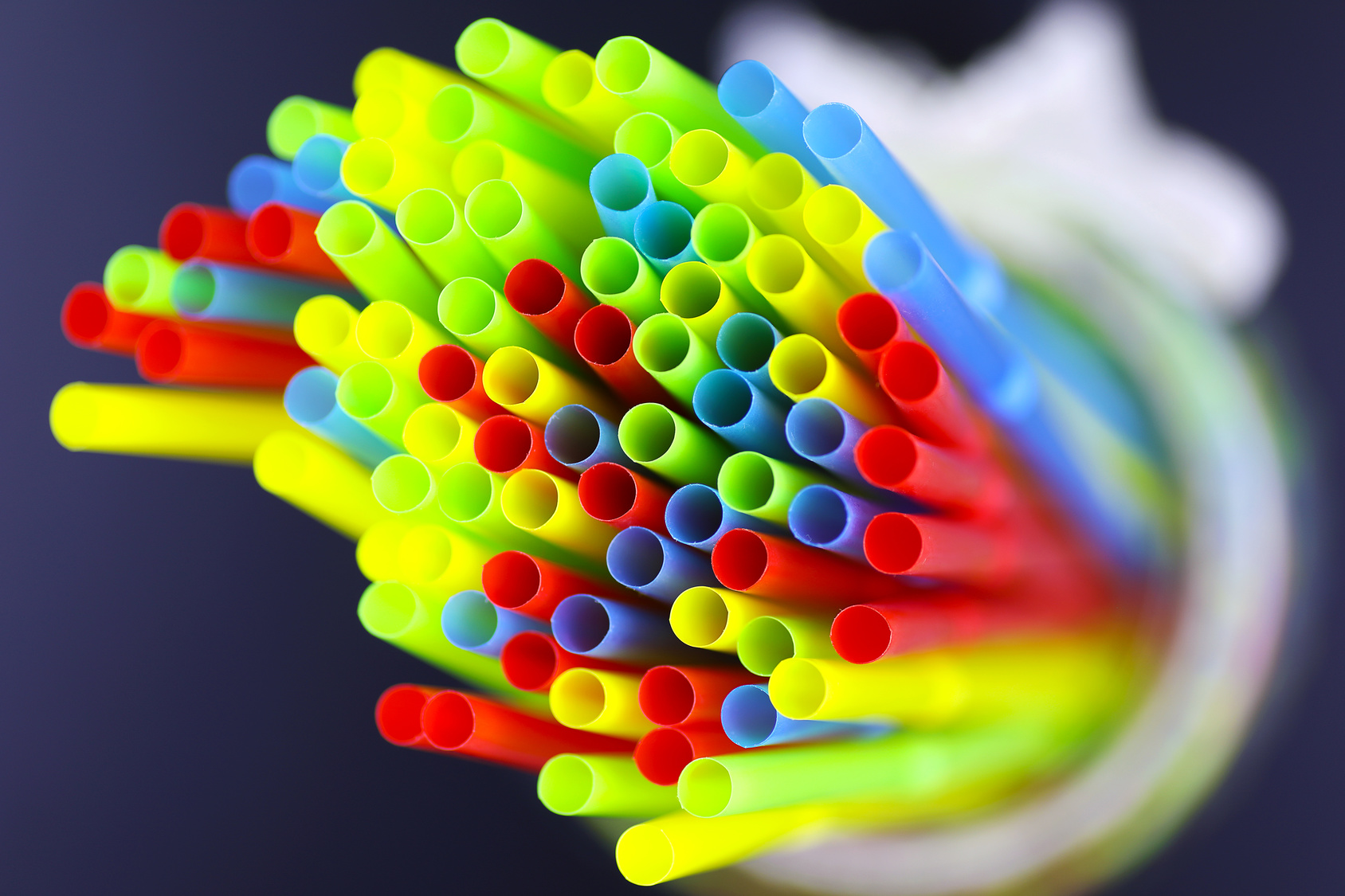 colored plastic cocktail tubes standing in a glass