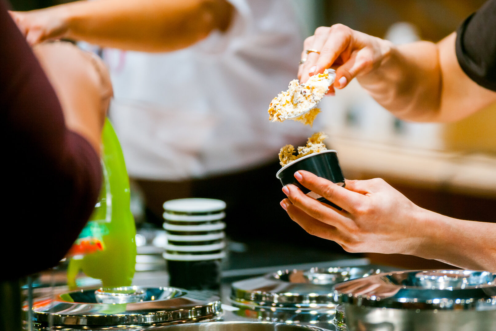 Gelataio prepara una coppetta di gelato in gelateria