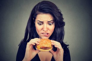 Young woman craving a tasty burger .