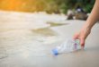 Hand woman picking up plastic bottle cleaning on the beach , volunteer concept spiaggia raccogliere bottiglia di plastica