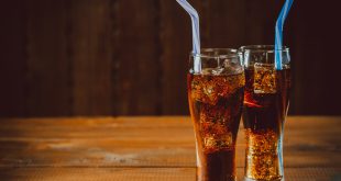 Beautiful cold drink of Cola with ice cubes with a boiler straws in glasses on wooden background with free space