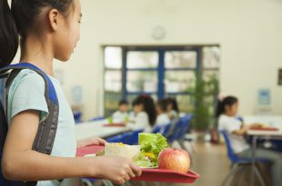 povertà alimentare, School girl holding food tray in school cafeteria