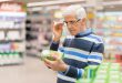 Senior man reading food label at a grocery store