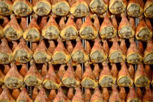 Cosce di maiale appese a stagionare per la produzione di prosciutto di Parma o San Daniele; concept: prosciuttopoli