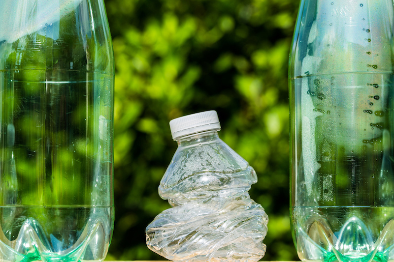 Three plastic bottles with one bottle crushed