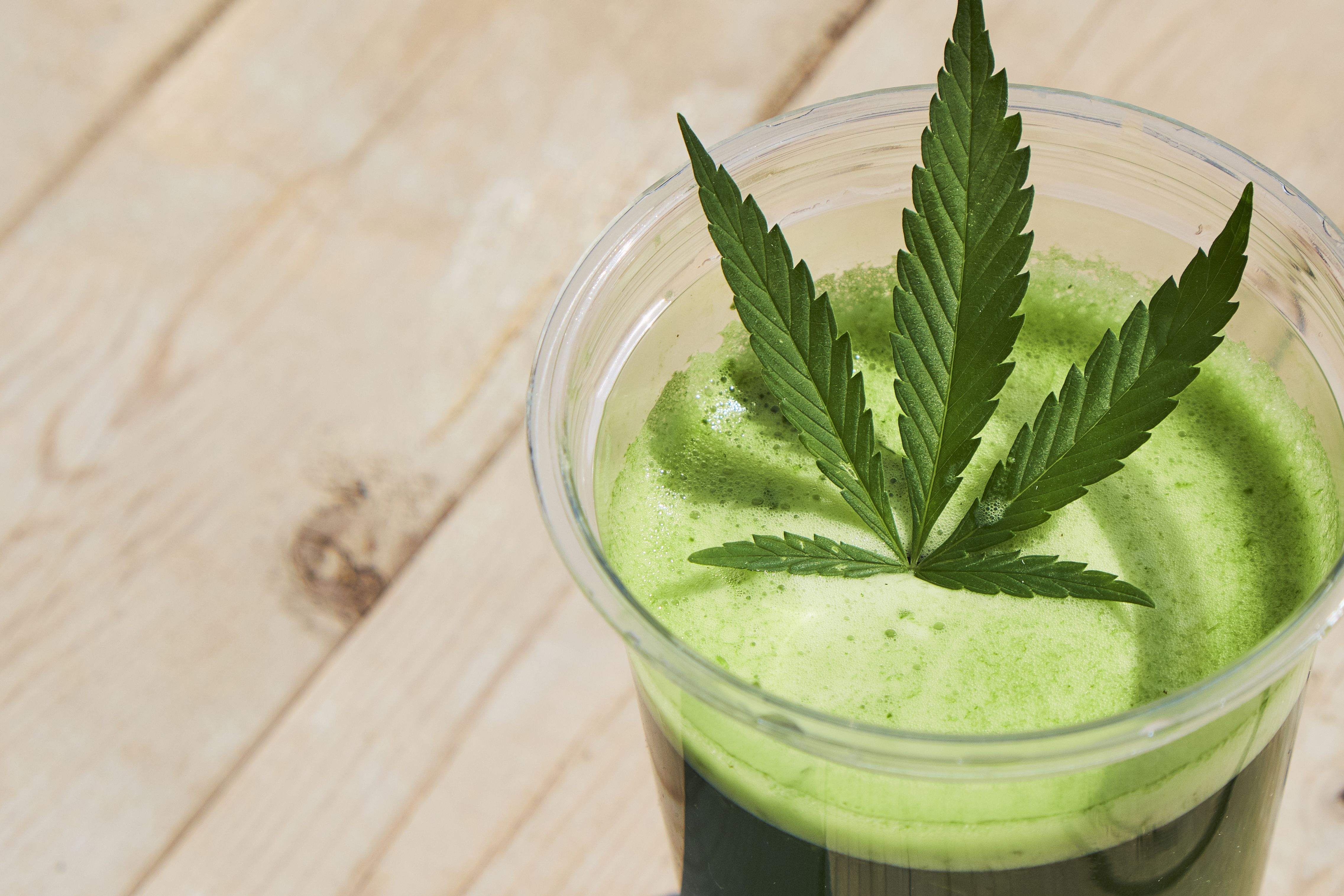 Healthy cannabis smoothie on wooden background. Natural supplement, detox and healthy living.