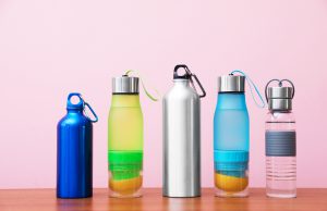 Different water bottles for sports on color background