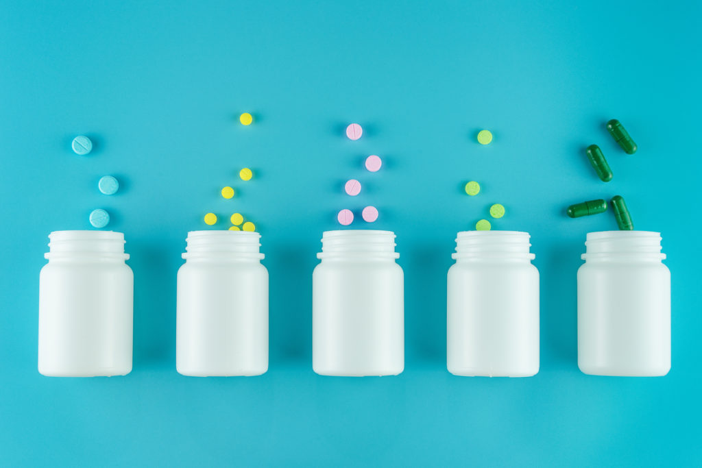 Medicines, supplements and drugs in a bottle on blue background