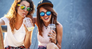 Two female friends hangout at the city street.Laughing and fun.Drinking juice.Two female friends hangout at the city street.Laughing and fun.Drinking juice.