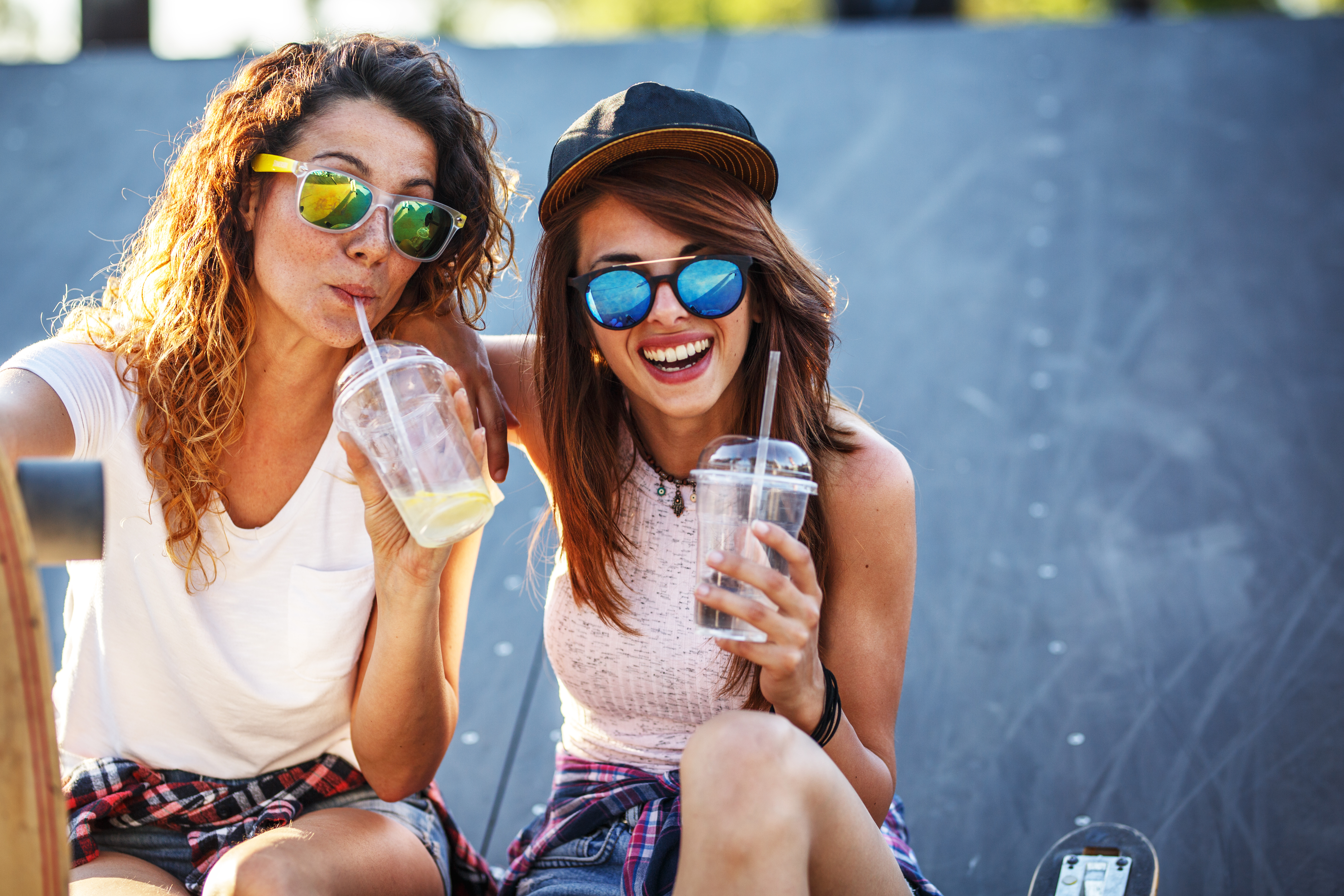 Two female friends hangout at the city street.Laughing and fun.Drinking juice.Two female friends hangout at the city street.Laughing and fun.Drinking juice.