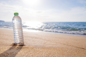Bottiglia di plastica su una spiaggia; concept: inquinamento