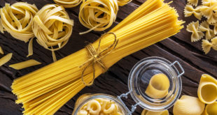 Different pasta types on the wooden table.