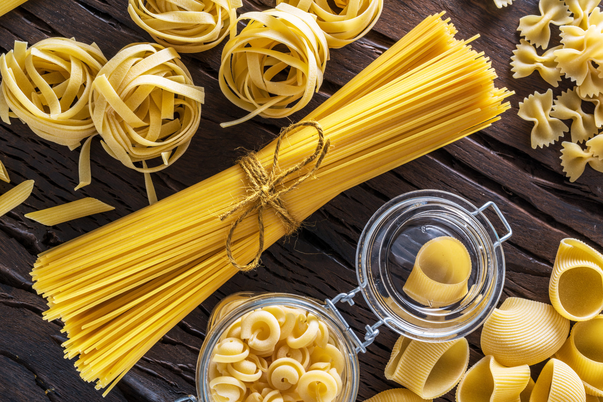 Diversi formati di pasta su un tavolo di legno