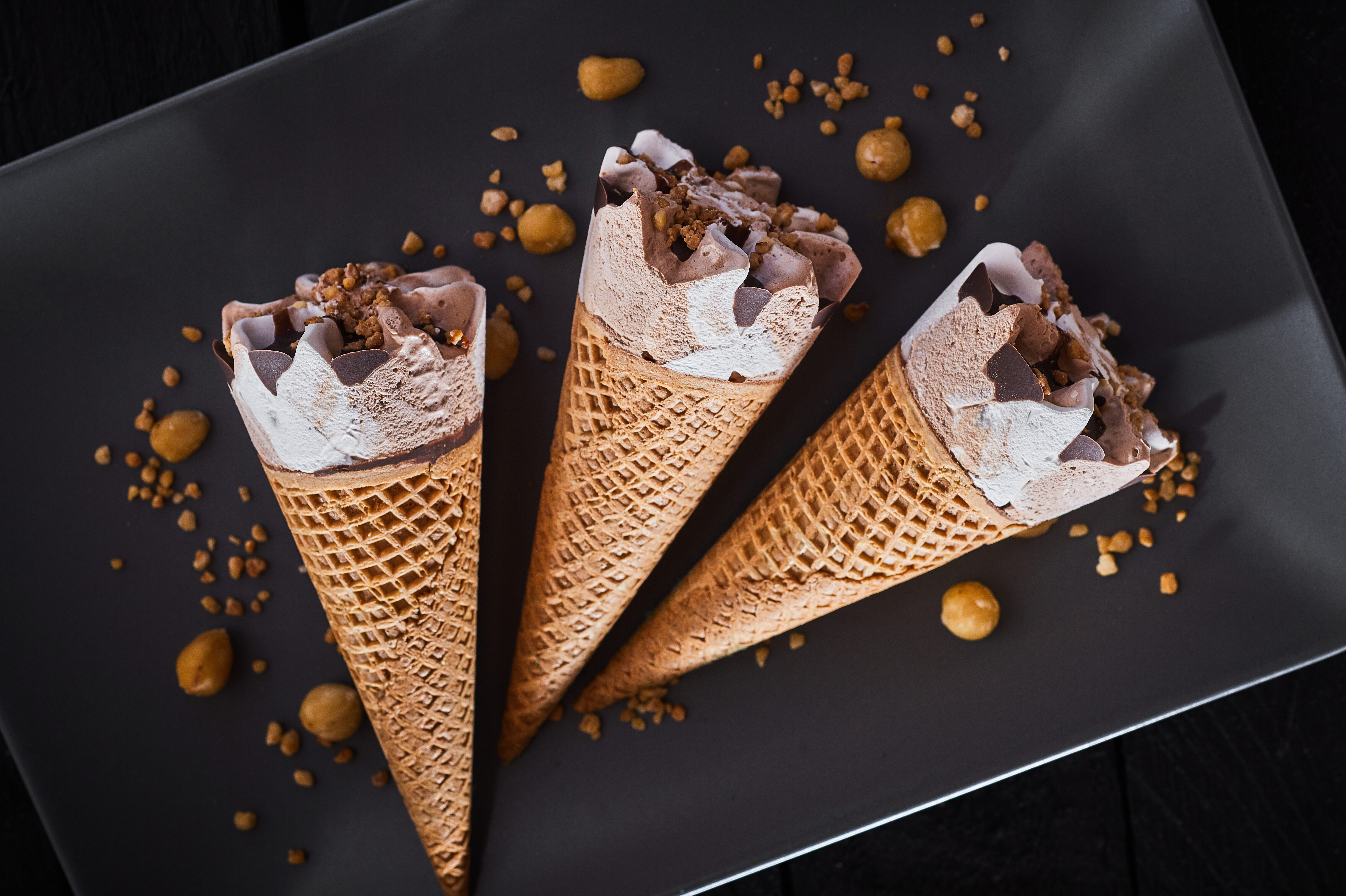 Tre coni gelato con panna, cioccolato e nocciola