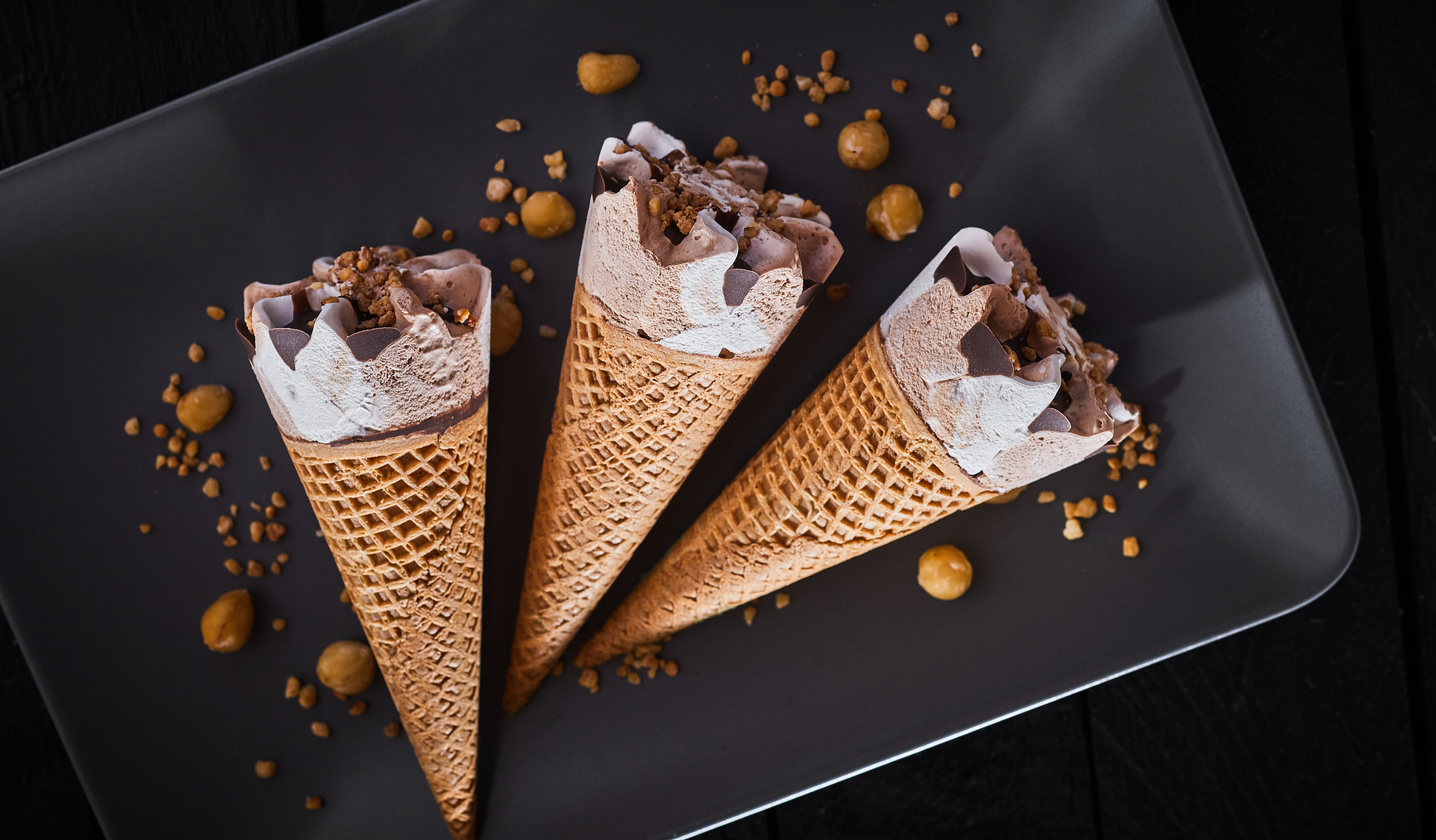 Three frozen ice cream desserts in sugar cones, concept: ultra-trasformati
