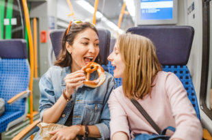 woman eating pretzel while traveling by train