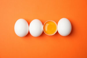 Uova di gallina crude su sfondo a colori, vista dall'alto