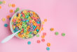 Colorful cereal on a pink background