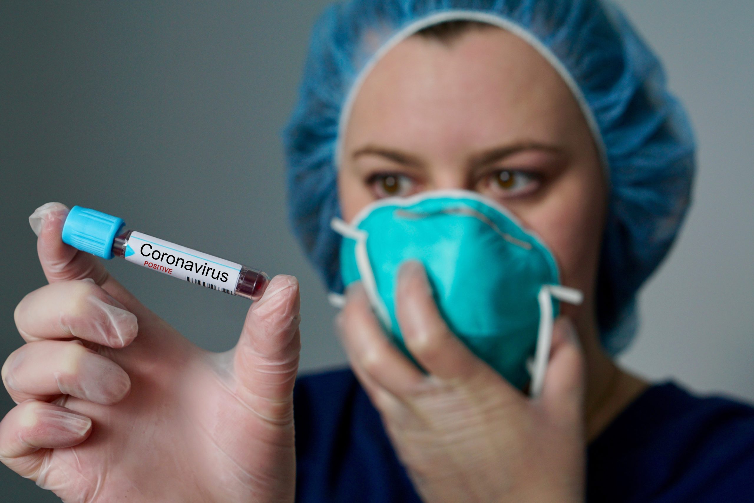 Nurse wearing respirator mask holding a positive blood test result for the new rapidly spreading Coronavirus, originating in Wuhan, China