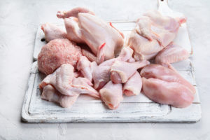 Pollo porzionato su un tagliere; concept: carne di pollo