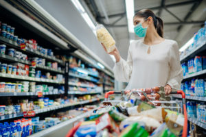packaging, Young person with protective face mask buying groceries/supplies in the supermarket.Preparation for a pandemic quarantine due to coronavirus covid-19 outbreak.Choosing nonperishable food essentials