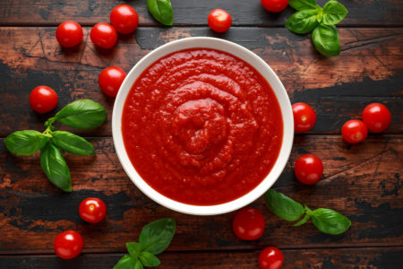 Passata di pomodoro fatta in casa in una ciotola bianca su un tavolo di legno. pomodori in scatola conserve alimentari