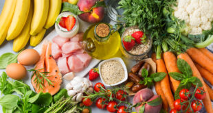 Alimenti della dieta mediterranea o dieta DASH visti dall'alto: carote, pomodorini avena, fragole, datteri, pesche, prugne, asparagi, salmone, pollo, olio extravergine di oliva, yogurt, banane, semi