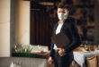 Handsome adult bearded man indoors in cafe. Lifestyle concept photo with copy space. Picture with gray laptop and protective mask on the face