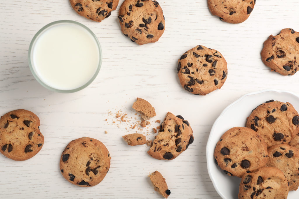 biscotti cookies con gocce di cioccolato su un tavolo con bicchiere di latte