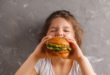 bambini schizzinosi, bambina che mangia mega hamburger