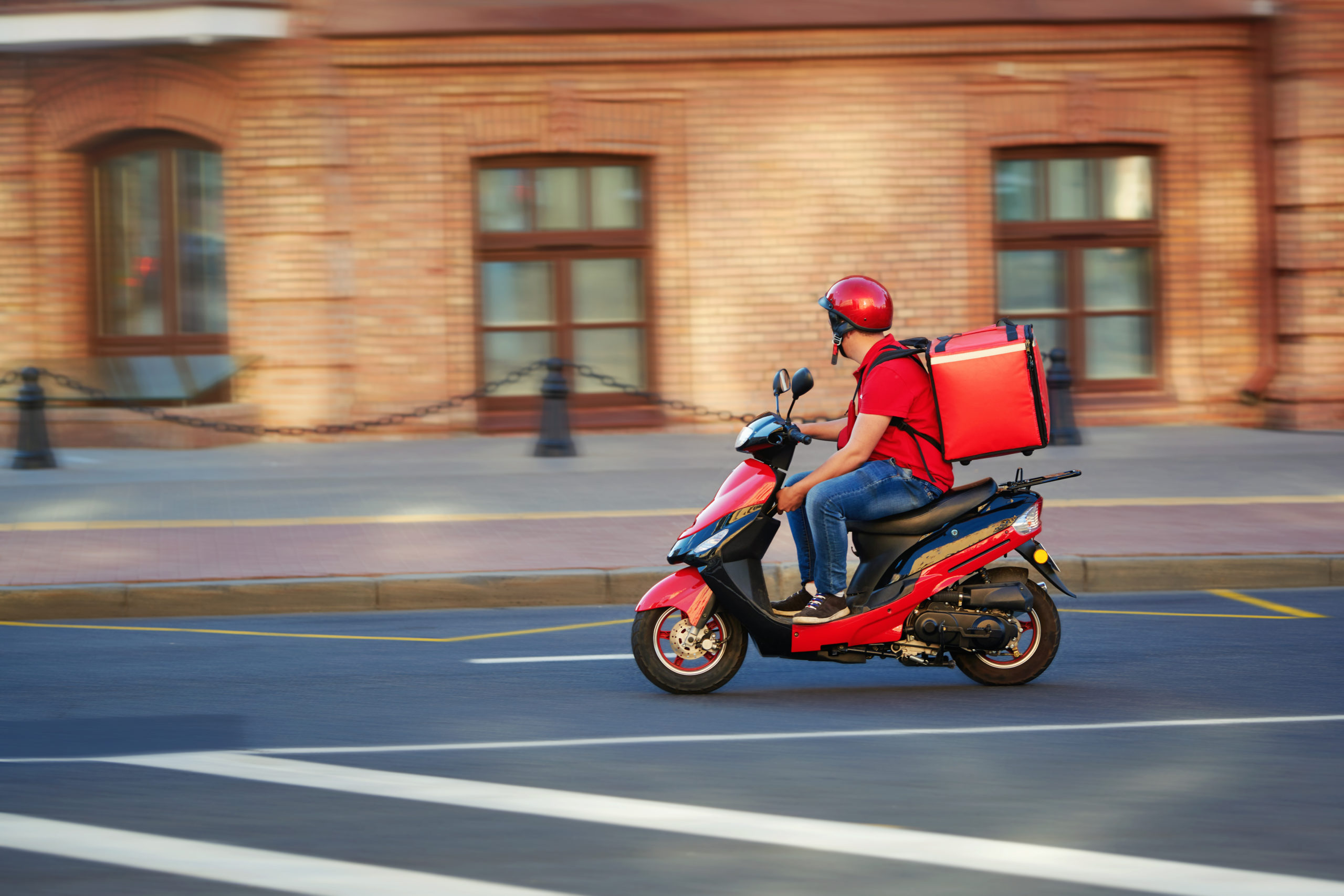 rider per servizio di food delivery su uno scooter con zaino termico