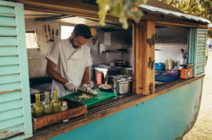 Un uomo prepara cibo in una cucina all'aperto per lo street food