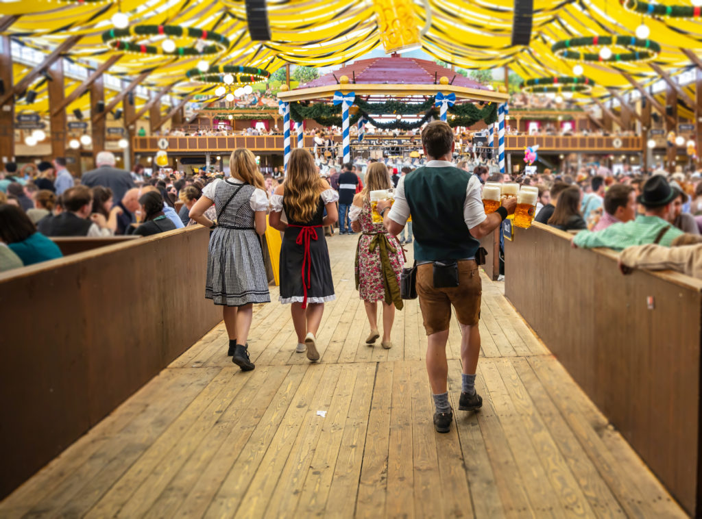 Cameriere e cameriere in abiti tradizionali bavaresi trasportano boccali di birra durante l'Oktoberfest