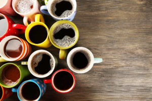 tazzine di caffè su tavolo di legno, a sinistra