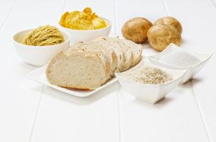 consumi, contenitori bianchi con dentro diversi derivati dei cereali, come pane, riso, pasta