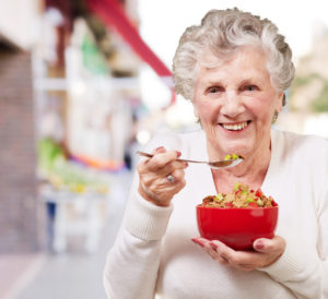 dieta, anziana che mangia una ciotola di cereali